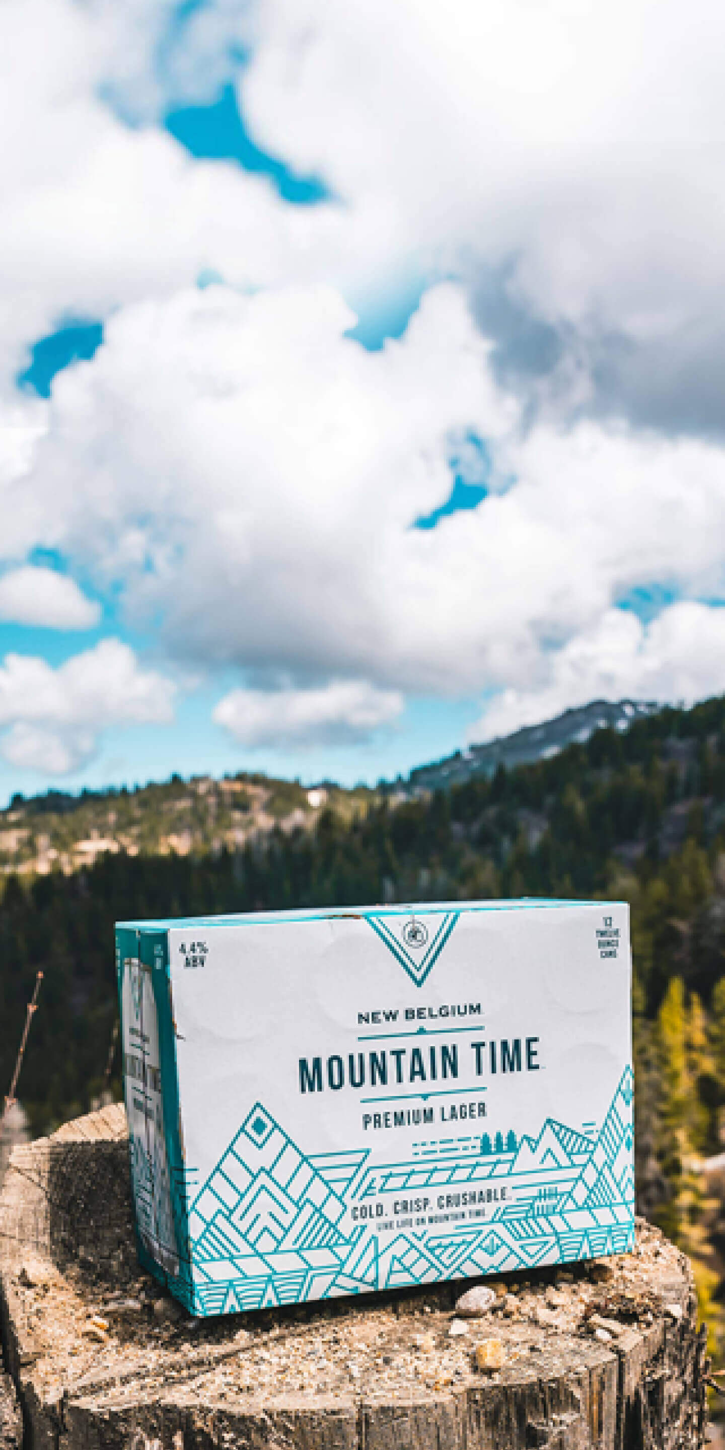 Case of Mountain Time Premium Lager sitting on a rock in the mountains.